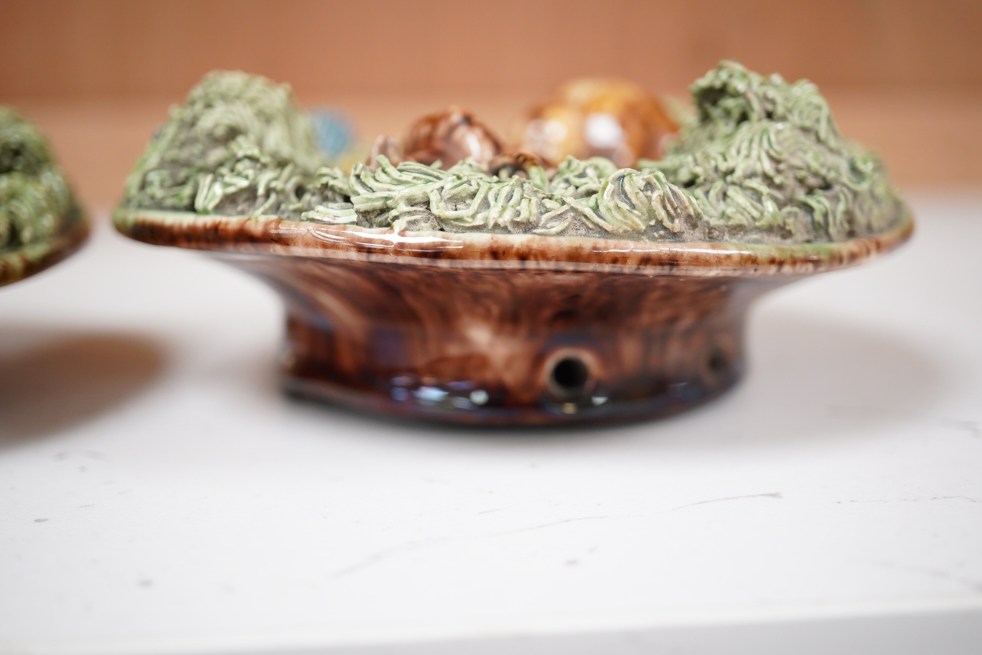 A pair of late 19th century Portuguese small circular Palissy style majolica plaques incorporating lizard and snail and with a mossy ground, impressed marks to reverse, 12cm diameter. Condition - fair